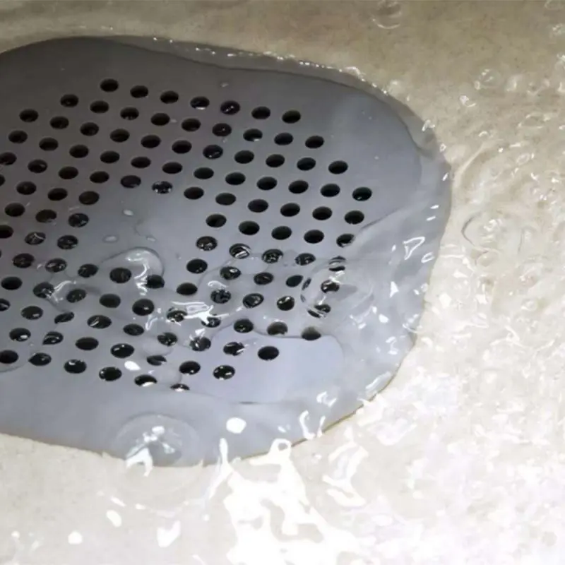 Graues quadratisches Abflusssieb mit Löchern im Wasser auf dem Abfluss